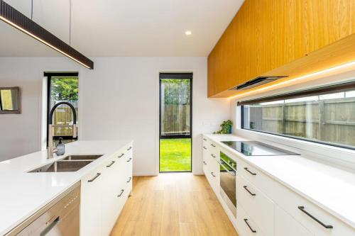 a kitchen with white counters and a large window at Elegant, Executive Retreat in Methven
