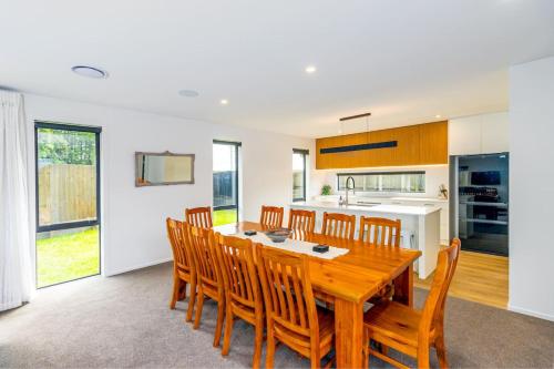 a kitchen and dining room with a wooden table and chairs at Elegant, Executive Retreat in Methven