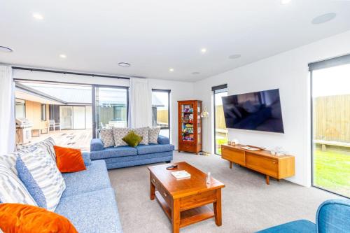 a living room with a blue couch and a table at Elegant, Executive Retreat in Methven