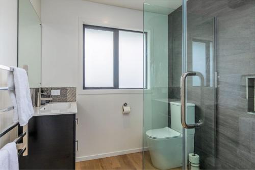 a bathroom with a toilet and a glass shower at Elegant, Executive Retreat in Methven