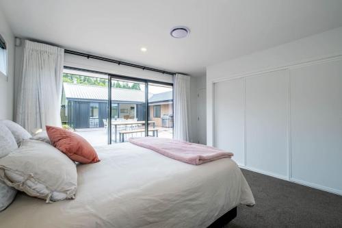 a bedroom with a bed and a large window at Elegant, Executive Retreat in Methven
