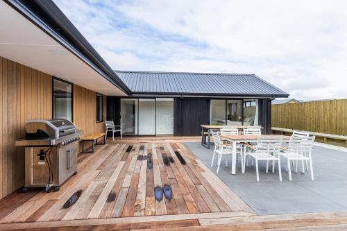 a deck with a grill and a table and chairs at Elegant, Executive Retreat in Methven