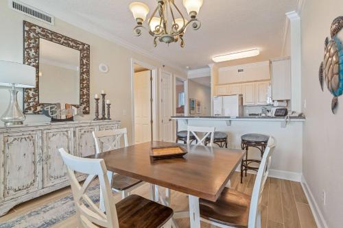 a dining room and kitchen with a wooden table and chairs at Island Royale 404 in Gulf Shores
