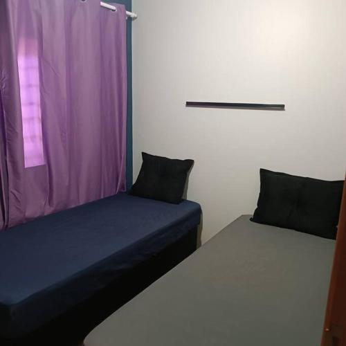 um quarto com 2 camas e uma cortina roxa em Gray House 4 Londrina - Pr (Jd. Santiago) em Londrina
