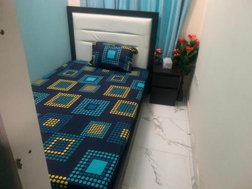 a bedroom with a bed with a blue and yellow at YOUR HOME in Dubai