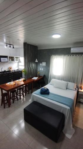 um quarto com uma cama grande e uma cozinha em Studio Girassol em Florianópolis