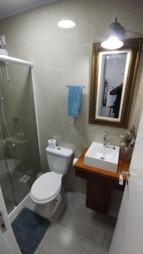 uma casa de banho com um WC, um lavatório e um chuveiro em Studio Girassol em Florianópolis