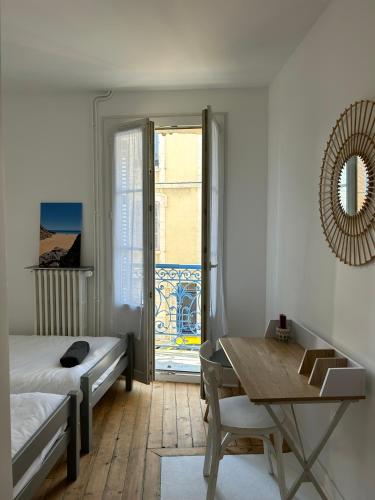 une chambre avec un lit, une table et une fenêtre dans l'établissement Grande maison de pêcheur - centre de Trouville, à Trouville-sur-Mer