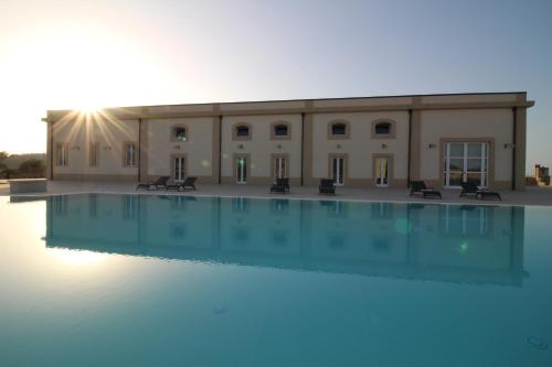a large swimming pool in front of a building at Dimora Savarino Marzamemi Suites with pool in Marzamemi