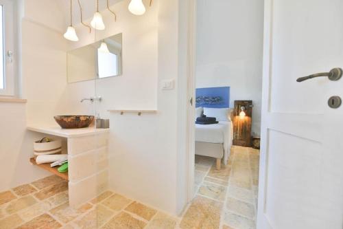 a white bathroom with a shower and a sink at LàMìa Donnagnora in Ostuni