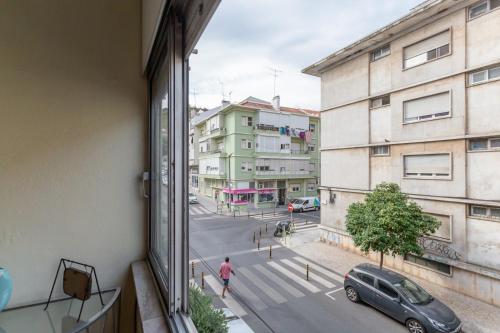 uitzicht op een straat vanuit een raam van een gebouw bij EVD-RENTALS OLIVAL BASTOS in Lissabon