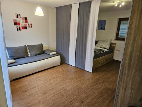 a living room with a couch and a bed at Einfaches ruhiges Apartment in Laichingen