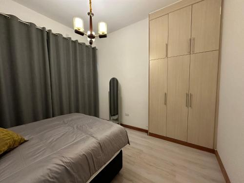 a bedroom with a bed and a dresser and curtains at Waterfalls Manor in Lusaka