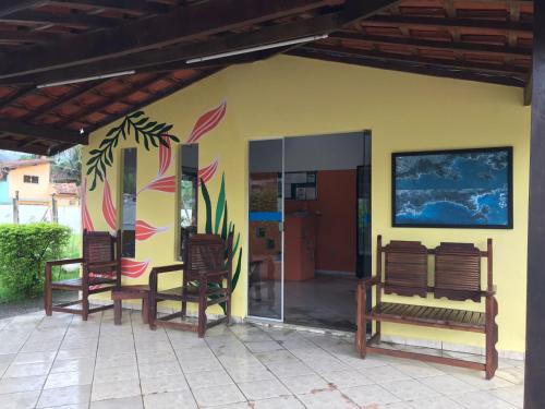uma casa com duas cadeiras e uma parede com um quadro em Pousada Ana e o Mar em Ubatuba