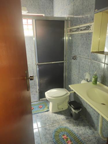 łazienka z toaletą i umywalką w obiekcie QUARTO CONFORTAVEL COM GARAGEM w mieście Holambra