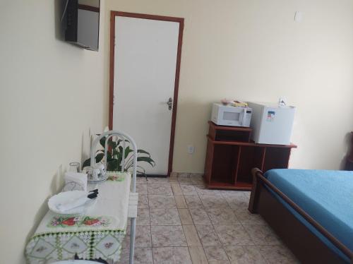 a room with a bed and a bird sitting on a table at QUARTO CONFORTAVEL COM GARAGEM in Holambra