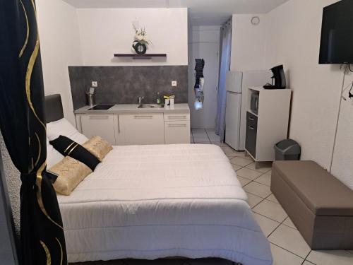um pequeno quarto com uma cama e uma cozinha em Naturistecapdagde APHRODITE em Cap d'Agde