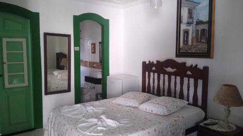 1 dormitorio con cama y puerta verde en Pousada Sonho Meu, en Paraty