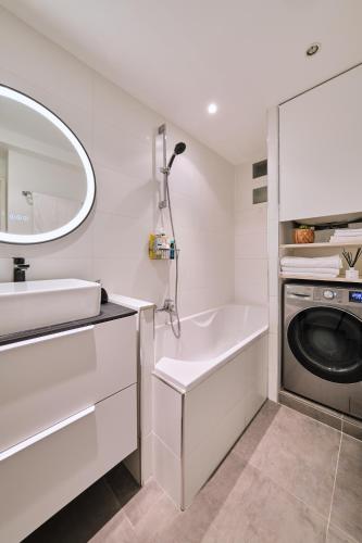 une salle de bain avec un lavabo et une machine à laver dans l'établissement Appartement parisien au cœur de Montparnasse, à Paris