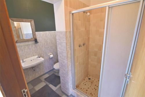 a bathroom with a shower and a sink and a toilet at Cottage on Diamond Street in Swakopmund