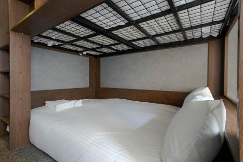 uma cama com lençóis brancos e almofadas num quarto em Sapporo - Apartment - Vacation STAY 29196v em Sapporo