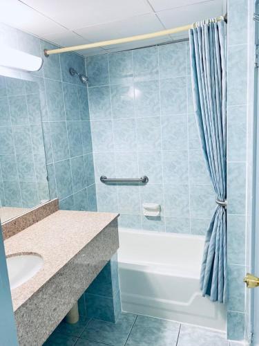 a bathroom with a tub and a sink and a shower at Tides Inn at Stehli Beach in Locust Valley