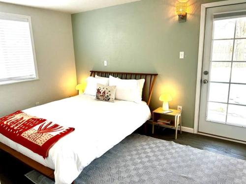 タオスにあるFully Furnished, Serene Taos Houseのベッドルーム1室(大型ベッド1台、窓2つ付)