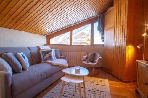 un salon avec un canapé et une table dans l'établissement Duplex du Piolet - Welkeys, à Huez