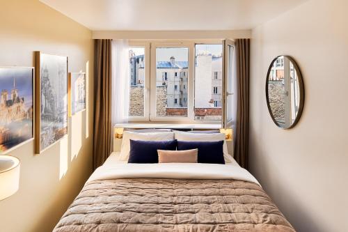 une chambre avec un grand lit et deux fenêtres dans l'établissement Appartement parisien au cœur de Montparnasse, à Paris