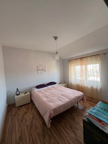 1 dormitorio con 1 cama en una habitación con ventana en Ovidius apartament, en Cisnădie