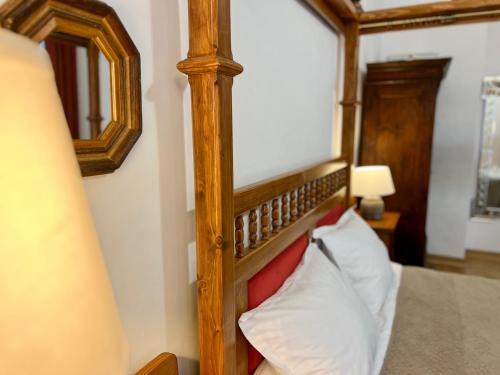 a bedroom with a wooden bed frame and a mirror at Zentrum Vintage Appartments in Braşov
