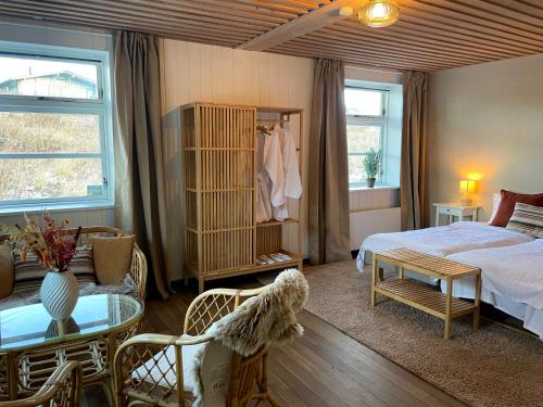 a bedroom with a bed and a table and chairs at Gilbjerg Strandhotel in Gilleleje