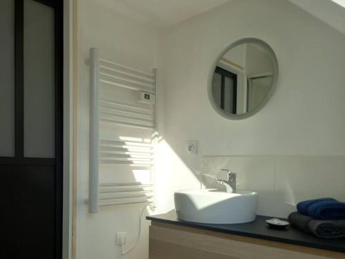 a bathroom with a sink and a mirror at Maison chaleureuse idéalement située 