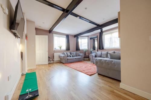 a living room with two couches and a flat screen tv at BIG House close to Metro Underground - Sleeps up to 13 in London