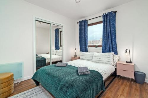 1 dormitorio con 1 cama grande y espejo en New Slick Finnieston Pad w/ Free Parking, en Glasgow