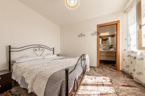 een witte slaapkamer met een bed en een spiegel bij Profumi del Borgo in San Biase