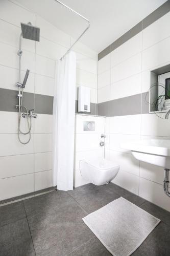 Baño blanco con lavabo y aseo en Gemütliches Apartment in der Nähe von Köln, en Hürth