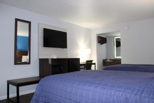 a hotel room with a bed and a flat screen tv at Motel 6 Saint George, SC – I-95 in Saint George