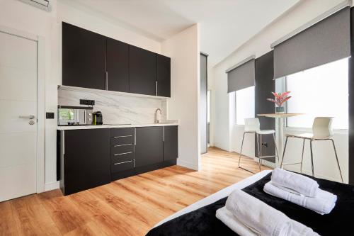 una cocina con armarios negros y un sofá en una habitación en Hermosilla Prime, by Presidence Rentals, en Madrid