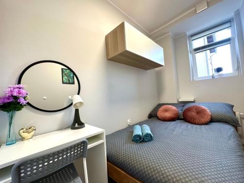 a bedroom with a bed with a mirror on the wall at MMRent Warmly Room in Gdańsk