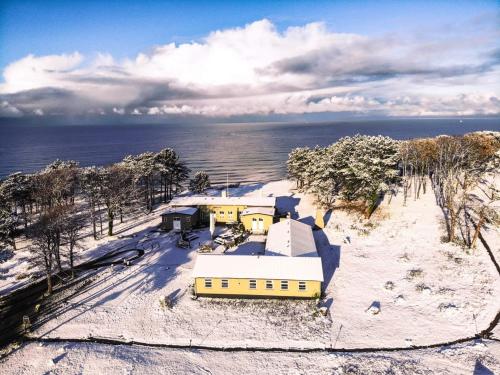 an aerial view of a yellow building in the snow at Gilbjerg Strandhotel in Gilleleje