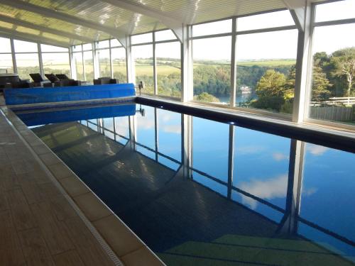 a swimming pool with a view of the water at Church Meadow in Golant