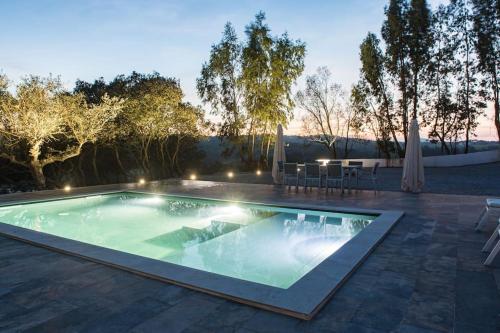 einen Pool im Hinterhof mit einem Tisch und Stühlen in der Unterkunft Monte da Falagueira by Portus Alacer in Arronches