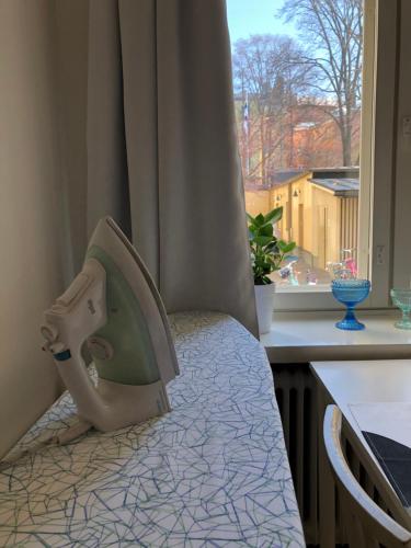 Schlafzimmer mit einem Bett mit einem Kopfteil und einem Fenster in der Unterkunft Modern city studio with own patio in Helsinki