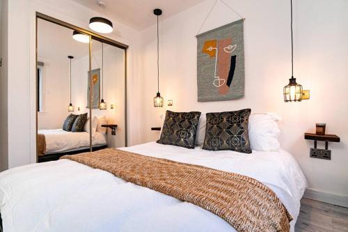 1 dormitorio con 1 cama con sábanas y almohadas blancas en Stylish City Pad with Free Private Parking, en Glasgow