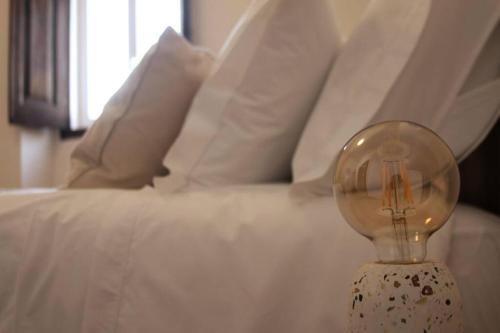 a light bulb sitting on a table next to a bed at Monte da Falagueira by Portus Alacer in Arronches