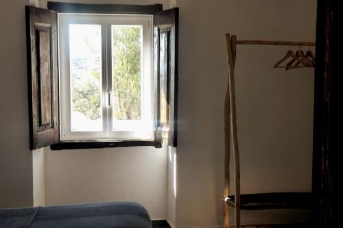 a room with a window and a blue couch and a mirror at Monte da Falagueira by Portus Alacer in Arronches