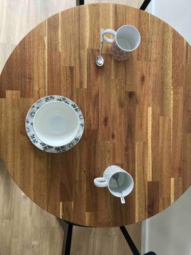 une table en bois avec des assiettes et des ustensiles dessus dans l'établissement Au coeur de la Vieille Ville - Vue Cathédrale, à Boulogne-sur-Mer