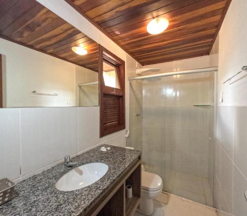 uma casa de banho com um lavatório, um chuveiro e um WC. em Pipa ,Bosque da Praia Flat 21 em Pipa