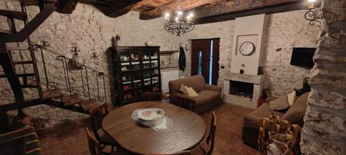 sala de estar con mesa, sillas y chimenea en Le rondinelle, en Castelnuovo Parano